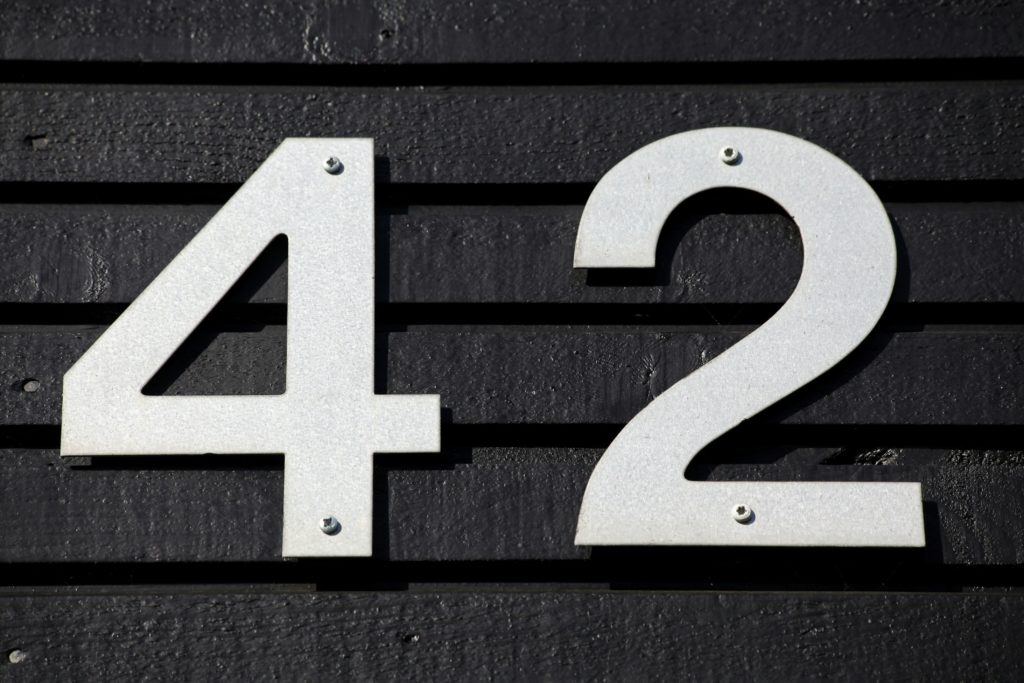 the number 42 attached to a wall. Photo by Mark König on Unsplash