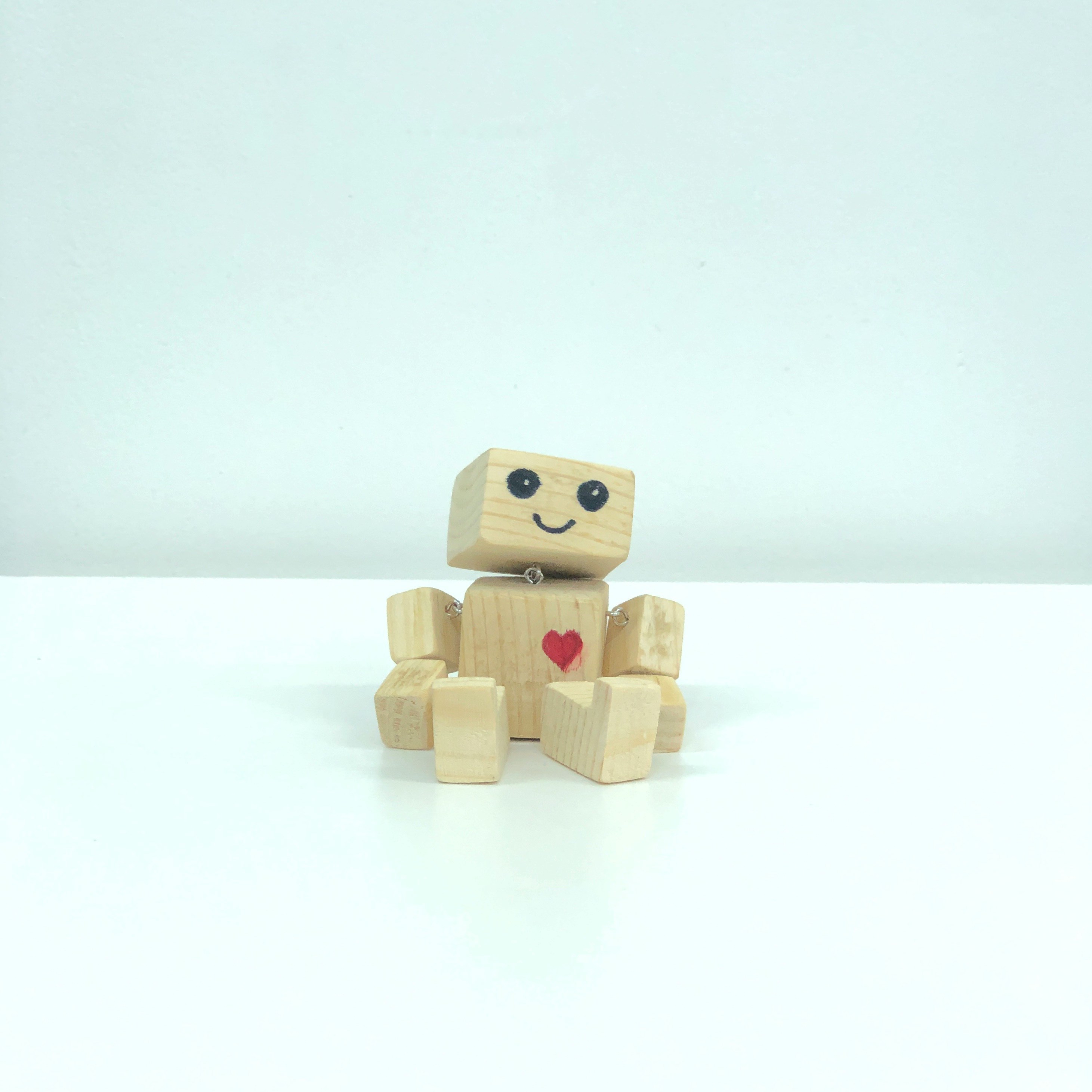 cute wooden "robot" with a heart drawn on the torso