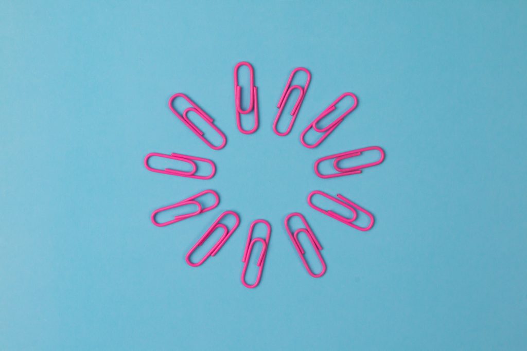 11 pink paperclips arranged in a circle