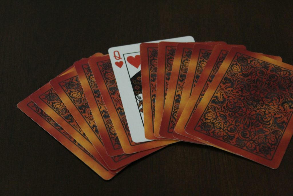 set of face down playing cards, with the queen of hearts showing