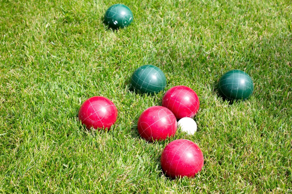 red and green bocce balls on a grassy field