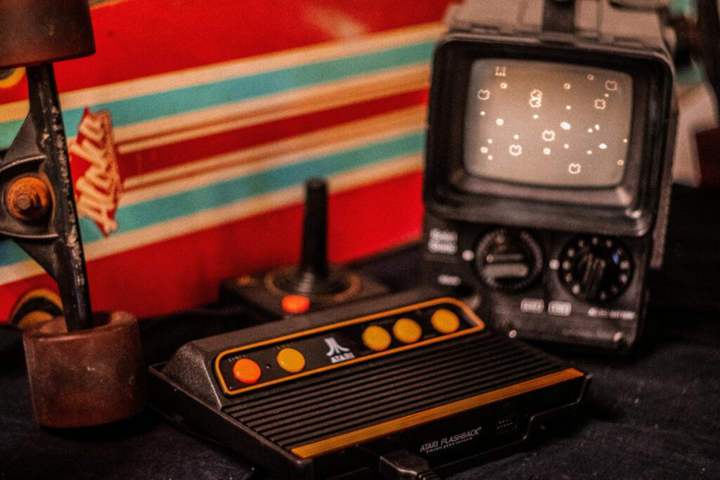 Atari Flashback console playing Asteroids connected to a portable television in front of a skateboard